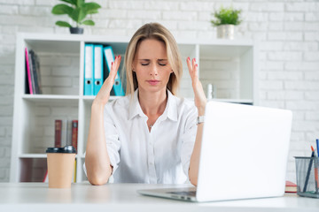 young attractive sad and desperate businesswoman suffering stress and headache at office laptop computer desk looking worried depressed and overwhelmed in business problem concept