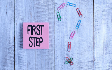 Writing note showing First Step. Business concept for Pertaining to the start of a certain process or beginning Pastel colour note paper placed next to stationary above wooden table