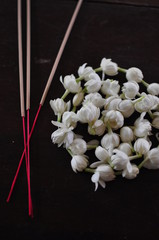 Fragrant jasmine blossom garland wrapped in circle on wooden table traditionally used as an offering to the ghosts and spirits in Thailand.