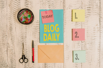 Word writing text Blog Daily. Business photo showcasing Daily posting of any event via internet or media tools Envelope letter sticky note ballpoint clips can scissors wooden background