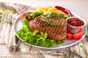 Grilled pork steak. A juicy piece of meat with vegetables, mushrooms, sauce and French fries. Restaurant menu. Isolated on white