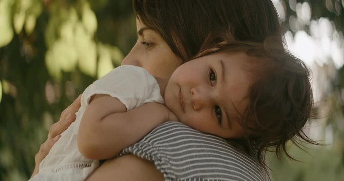 Mother comforting sad baby girl. Shot in 4K RAW on a cinema camera. Anamorphic bokeh.