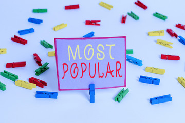 Conceptual hand writing showing Most Popular. Concept meaning Liked Followed Enjoyed by majority of the showing in a society Colored clothespin papers empty reminder white floor office