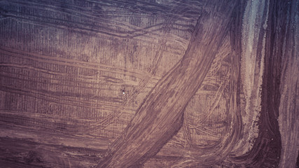 An aerial image looking down on a construction site with a color profile applied.  The image has the appearance of a streaked paint on glass, but on closer examination, you can see the tracks of the e