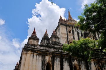 Fototapeta na wymiar looking up to exterior corner of Thatbyinnyu Temple under sunny blue sky white clouds. The highest pahto in Bagan Myanmar. 
