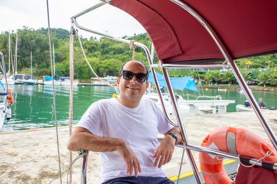 Delighted tourist man on sailboat boat trip during vacation