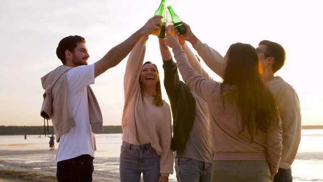 friendship and leisure concept - group of happy friends toasting non alcoholic drinks on summer beach