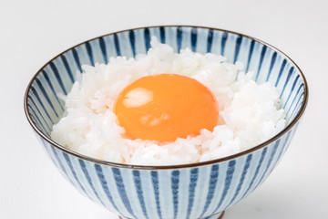 白い背景にお茶碗に白ご飯に生卵  卵かけご飯egg rice 