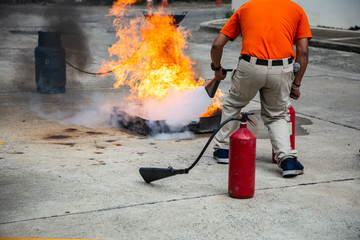 Firemen using extinguisher and water for fight fire during firefight training. All fighter wearing...