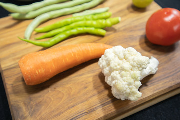 Close up of Fresh healthy vegetables ready to chop on wooden plate
