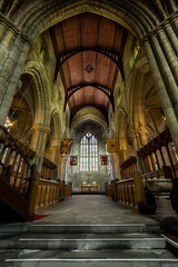 Wide angle shot of the interior of a scottish gothic cathedral, with a wooden vault and stained glass