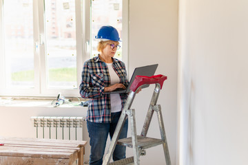 Woman Builder in the room making repairs.