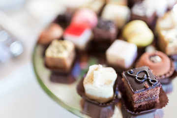 Close up of a silver tray of pastries, with a brownie in foreground, against a bokeh background