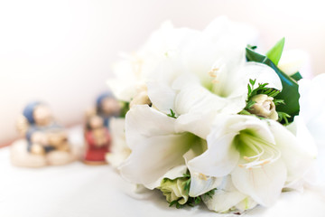 Close up of a white wedding bouquet lying on a table against a bokeh background