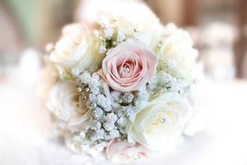 Close up of wedding bouquet made up white and pink roses against a bokeh background