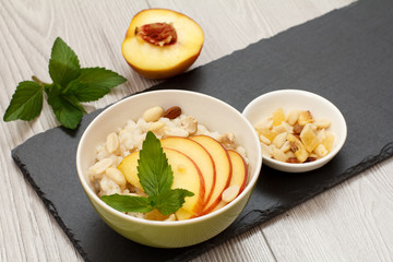 Sorghum salad with nuts and fresh peach on stone board.