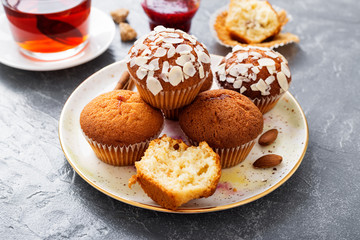 Homemade muffins with almond flakes and raspberry jam.