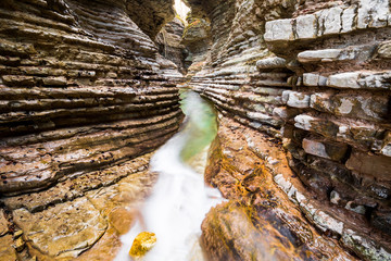 Interior of Brent De L'Art, a slot canyon in northern Italy, with a small creek running in the...