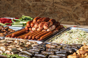 Culinary Buffet with healthy take away meal - grilled vegetables, fish and meat on the street food culinary market, festival, event.  Different types of delicious meat. Outdoor Cuisine.