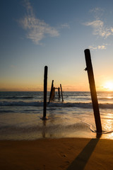 Sunset on the Khao Pilai beach with old wooden bridge and lens flare
