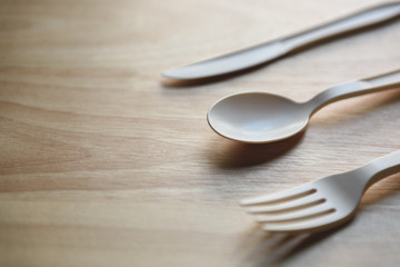 Biodegradable plastic lunch box, spoon and fork made from starch on wooden background