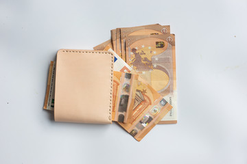 Leather wallet with euro money bill on white background