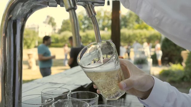 Close up of a glass in which beer, cider or lemonade, bubbles in a glass are poured