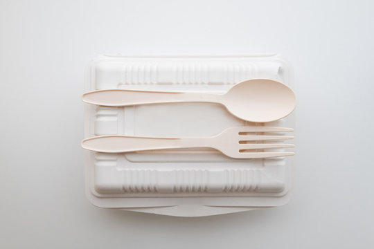 Biodegradable plastic spoon, fork and lunch box on white background isolate