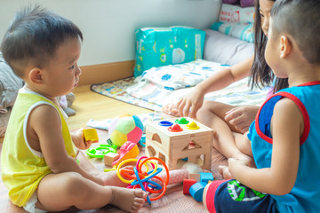 Group of children playing together with wooden toy box