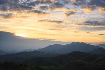 Fototapeta na wymiar Silhouette of Mountain With Fluffy Clouds during Sunrise at Noen Chang Suek, Kanchanaburi, Thailand
