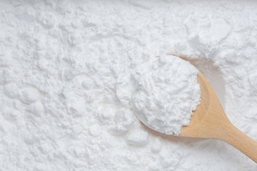 Close-up of tapioca starch or flour powder in wooden spoon with starch background