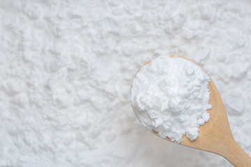 Close-up of tapioca starch or flour powder in wooden spoon with starch background