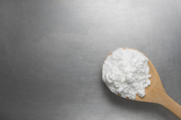 Close-up of tapioca starch or flour powder in wooden spoon with starch background
