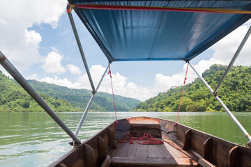 Traditional wooden boat in a picture rainy season at Prakarnchon Khun Dan Dam, Nakhon Nayok, Thailand