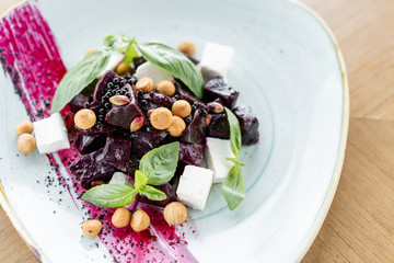 Healthy diet food. Italian salad with beetroot, basil leaves and cheese feta, with oil and small profiteroles.