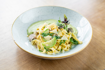 Italian pasta tagliatelle with zucchini, Turkey and green sauce. Parmesan cheese