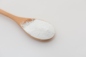 Close-up of tapioca starch or flour powder in wooden spoon with white background isolated