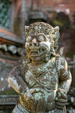 Traditional stone statue depicting demon, god and Balinese mythological deities in Ubud, island Bali, Indonesia . Stone statue hand with sign of fig