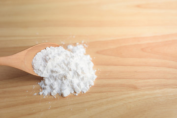 Close-up of tapioca starch or flour powder in wooden spoon with white background isolated