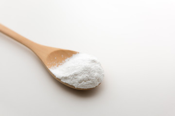 Close-up of tapioca starch or flour powder in wooden spoon with white background isolated