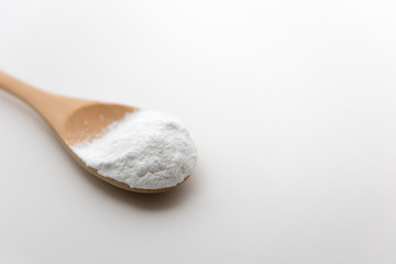 Close-up of tapioca starch or flour powder in wooden spoon with white background isolated