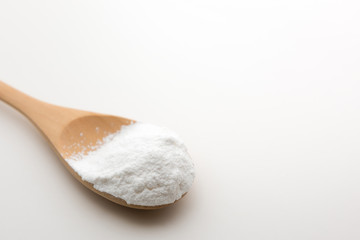 Close-up of tapioca starch or flour powder in wooden spoon with white background isolated
