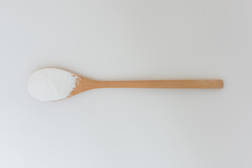 Close-up of tapioca starch or flour powder in wooden spoon with white background isolated