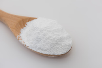 Close-up of tapioca starch or flour powder in wooden spoon with white background isolated