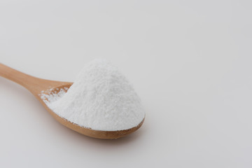Close-up of tapioca starch or flour powder in wooden spoon with white background isolated