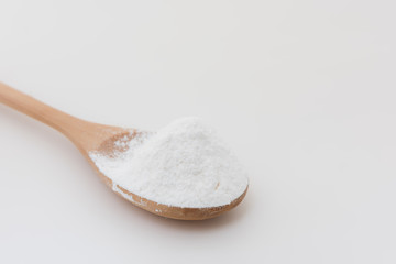 Close-up of tapioca starch or flour powder in wooden spoon with white background isolated