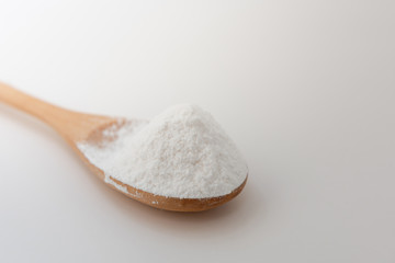 Fototapeta na wymiar Close-up of tapioca starch or flour powder in wooden spoon with white background isolated