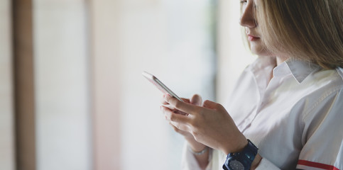 Close-up view of young businesswoman looking for new informations on smartphone