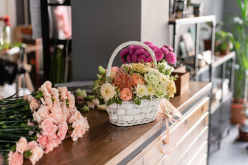 Beautiful flower composition a bouquet in a wicker basket. Floristry concept. Spring colors