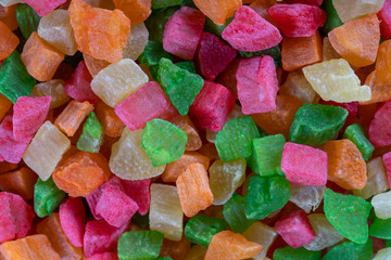 Background candied colorful fruit. Dried pineapple bits. Colored dried tropical fruit. Close up
